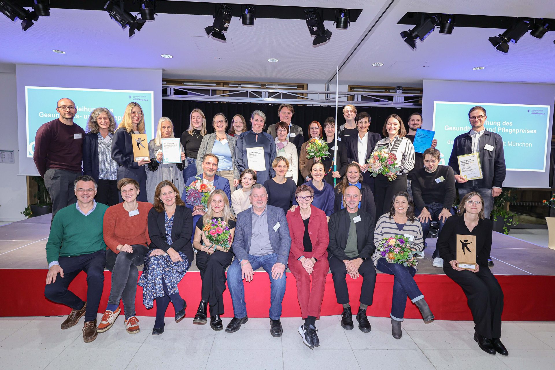 Feiernde Personnen auf einer Bühne